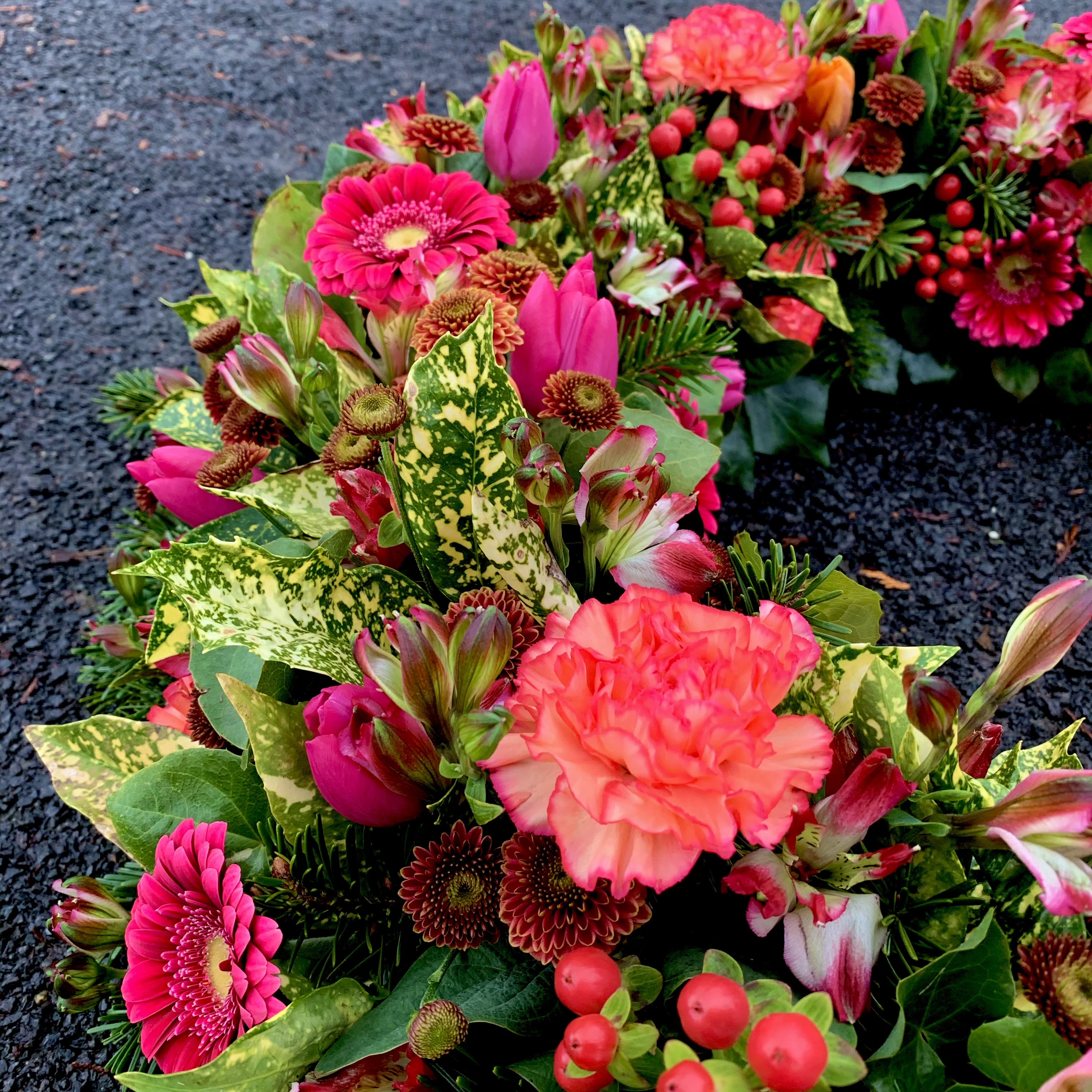 Rundgesteckter Kranz in orange-rot-pink Farbtönen 